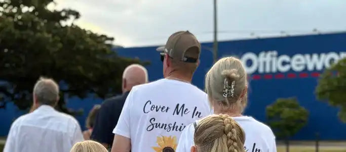 White t-shirt with ’Cover Me In Sunshine’ text printed on the back.